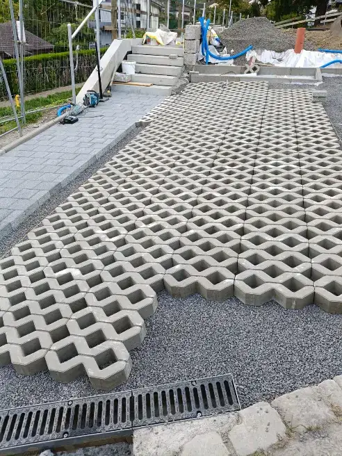 Accès et stationnement — Vue de la surface en dalles à engazonner et du raccord au cheminement.