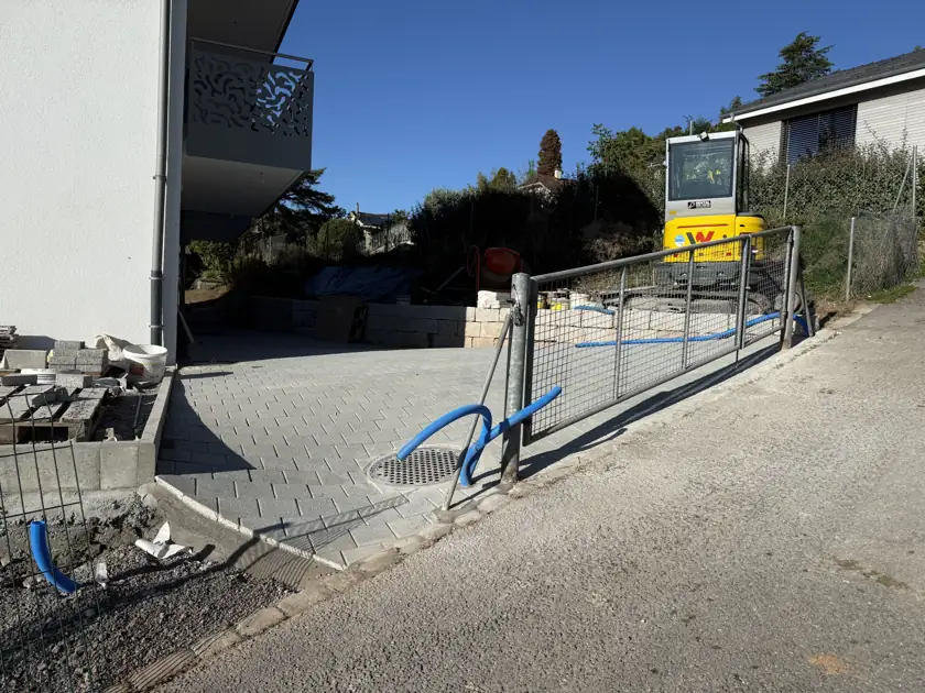 Aménagement côté accès — Vue des surfaces aménagées ; certains équipements et travaux restent visibles sur le chantier.