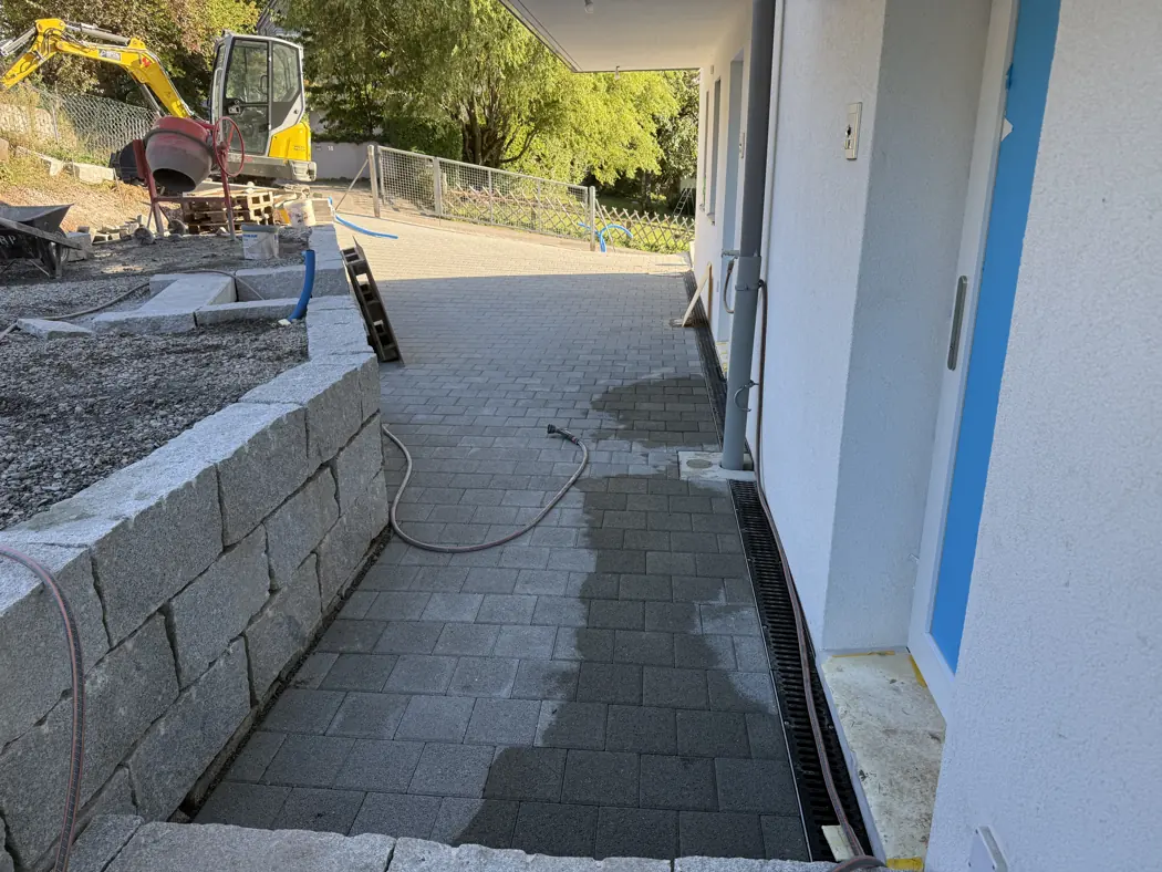 Terrasses et cheminements — Vevey · cheminement pavé entre la façade et le mur en blocs de pierre.